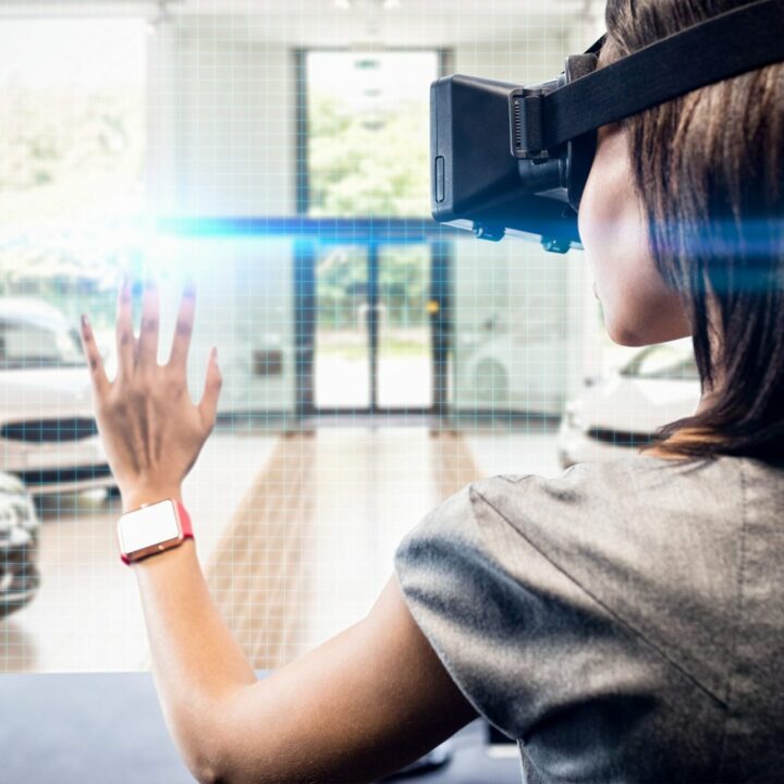 Frau benutzt ein Virtual-Reality-Gerät vor der Aussicht auf eine Reihe neuer Autos.