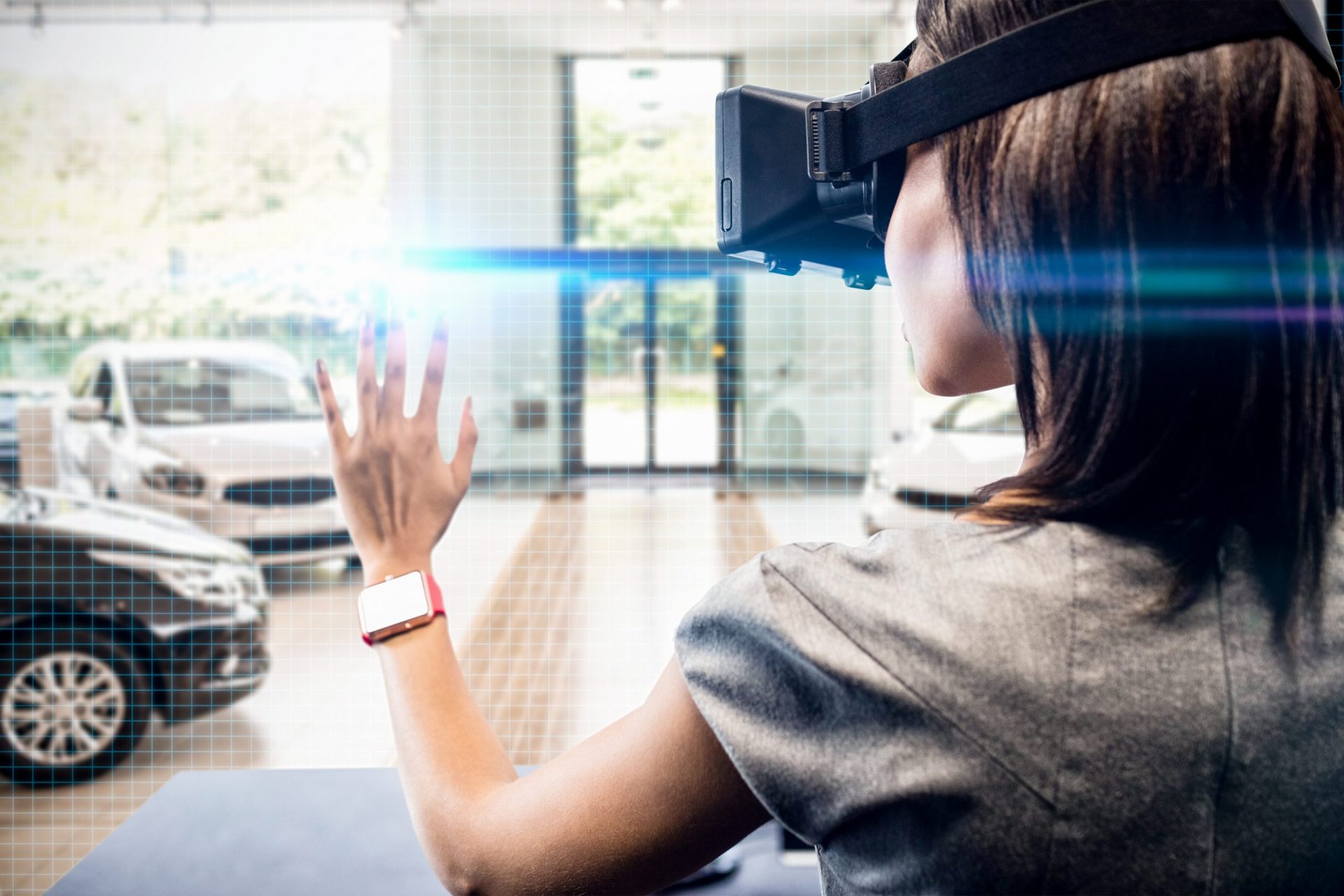 Frau benutzt ein Virtual-Reality-Gerät vor der Aussicht auf eine Reihe neuer Autos.