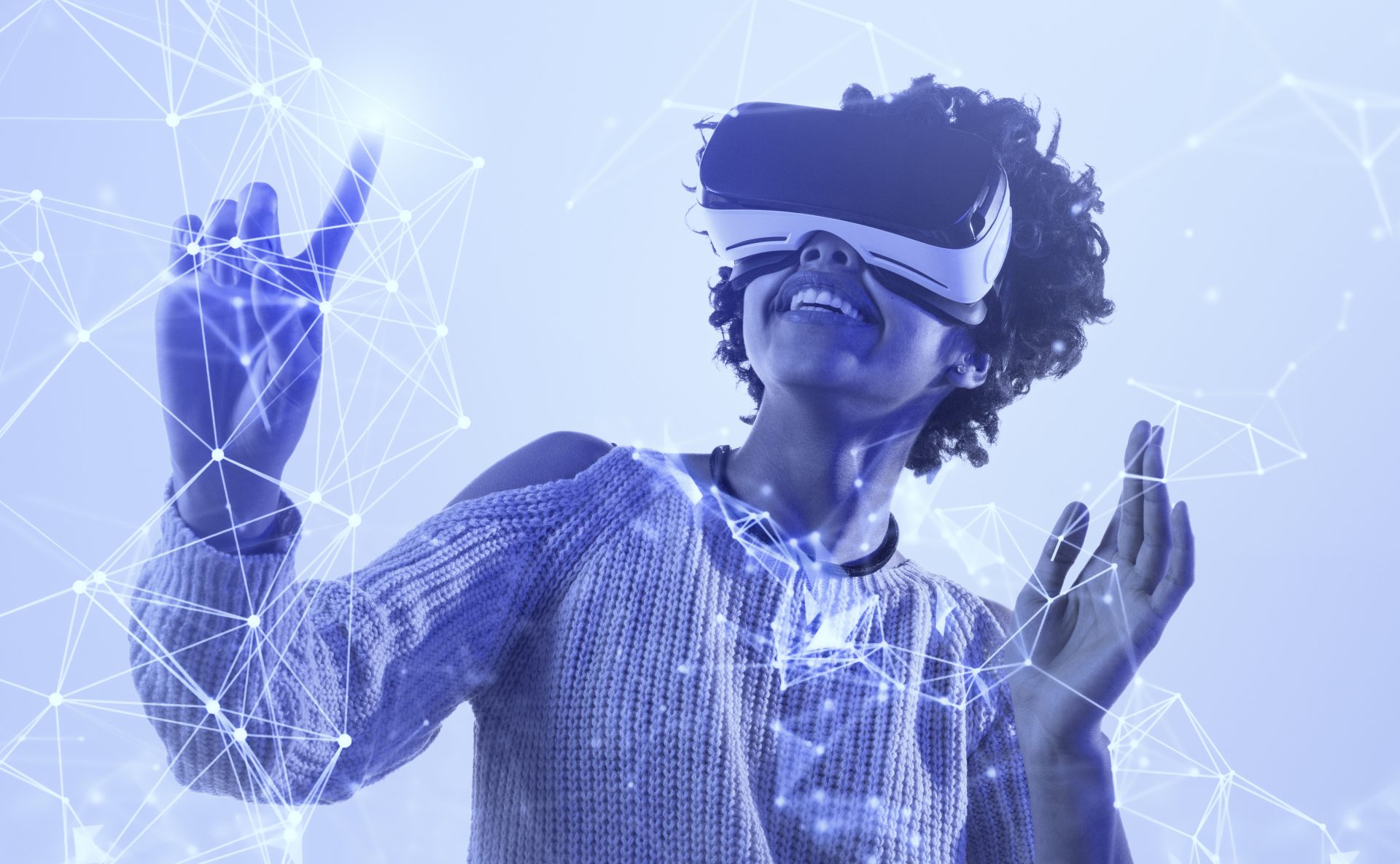 Begeisterte schwarze Frau in VR-Brille lächelt und berührt ein komplexes Netzwerk, während sie unter blauem Licht die virtuelle Realität erkundet.