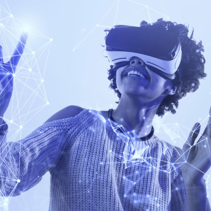 Begeisterte schwarze Frau in VR-Brille lächelt und berührt ein komplexes Netzwerk, während sie unter blauem Licht die virtuelle Realität erkundet.exploring virtual reality under blue light